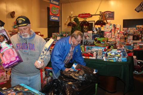Lake City Elk Club 893 members Michael Lydick (left) and Larry Ward work on arranging toys Thursday afternoon as they prepare for the annual Elks Club Children’s Christmas Party, which will take place at about 5 p.m. on Christmas Eve. (TONY BRITT/Lake City Reporter)