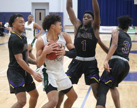 Columbia guard Jordan Smith (0) and forward Marcus Peterson (1) surround Evans’ guard Deshaun Osborne during Monday’s game at the Hitchcock’s Challenge. (JORDAN KROEGER/Lake City Reporter)