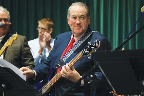 Former Arkansas Governor Mike Huckabee plays bass with local rockers Tuesday night at FGC. (CAMERON VINING/Special to the Reporter)