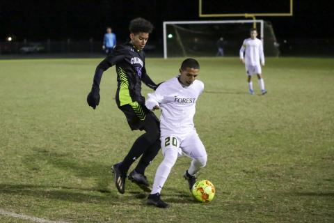 Columbia’s Ismael Cisse chases down possession from Forest’s Gavin Palawski on Tuesday night. (BRENT KUYKENDALL/Lake City Reporter)
