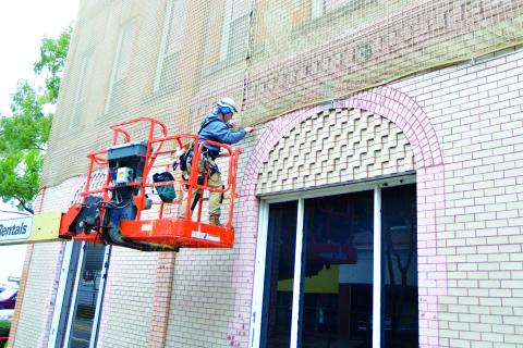 A worker installs netting around City Hall on North Marion Avenue to keep bricks from falling onto pedestrians in this November 2018 file photo. (FILE)