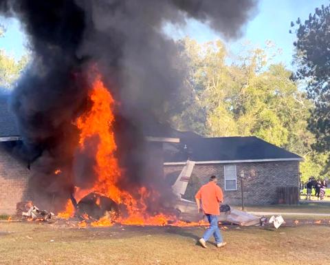 A single-engine plane is seen in flames after crashing into a home in Cannon Creek Airpark Saturday morning. (Photo courtesy of AMY BROWN/Facebook)