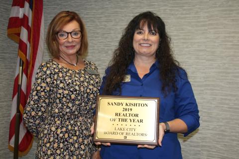 Susan Eagle (left), the 2020 Lake City Board of Realtors President, stands with Sandy Kishton after she presented Kishton with the 2019 Realtor of the Year Award during Monday’s Lake City Board of Realtors 2020 Installation Luncheon at the Lake City Holiday Inn. (TONY BRITT/Lake City Reporter)