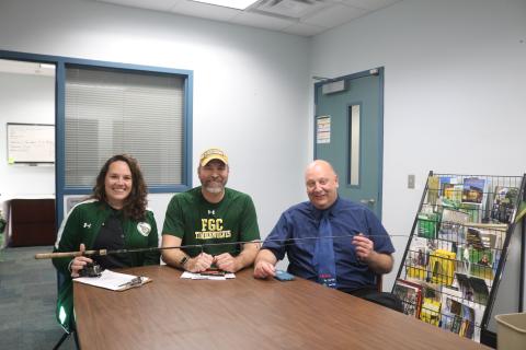 Rebecca Golden (from left), FGC athletic coordinator, sits with Rob Chapman, FGC coordinator of enrollment and marketing and webmaster, and Lawrence Barrett, FGC president, as the three hold a fishing rod and reel during the school’s announcement on Friday that it will launch a competitive bass fishing team. The FGC Bassmasters plan to compete during the 2020-21 school year. (TONY BRITT/Lake City Reporter)
