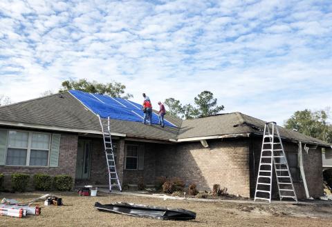 Among those volunteering to patch the roof of a home hit by a plane Saturday were Bill Brinkley (from left), Alvin Hitson and Mark Nodes. Photo by Robert Bridges/Lake City Reporter