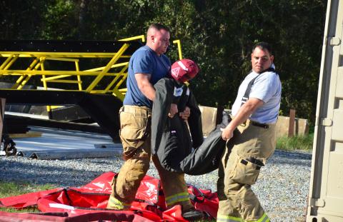 Firefighters lug a search-and-rescue dummy. Friday’s drills marked the end of a week-long gauntlet of training exercises, the first time CCFR has hosted personnel from agencies outside the county. (CARL MCKINNEY/Lake City Reporter)