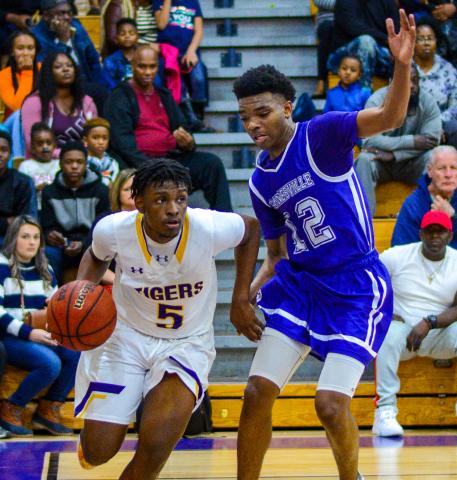 Columbia guard Darrien Jones drives by Gainesville’s Alex McCray on Tuesday night. (THOMAS RICKS/Special to the Reporter)