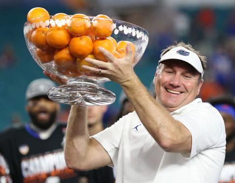 Florida head coach Dan Mullen raises the championship bowl of oranges after the Gators defeated Virginia in the Capital One Orange Bowl at Hard Rock Stadium on Dec. 30, 2019, in Miami Gardens. (AL DIAZ/Miami Herald/TNS)