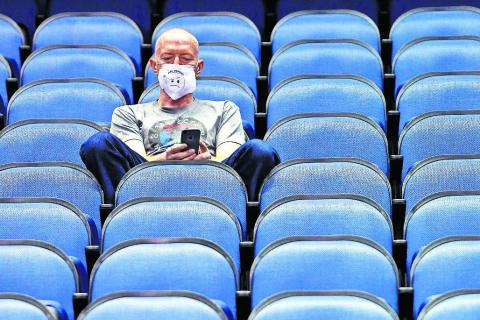 Mike Lemcke, from Richmond, Va., sits in an empty Greensboro Coliseum after the games were canceled at the Atlantic Coast Conference basketball tournament in Greensboro, N.C. (BEN McKEOWN/Associated Press)