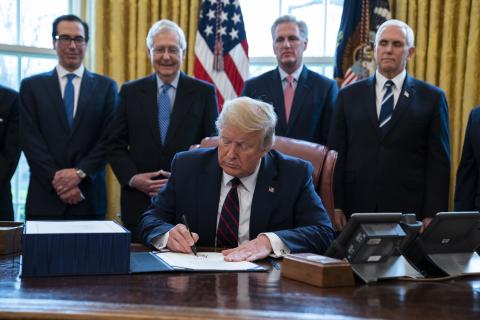 President Donald Trump signs the coronavirus stimulus relief package in the Oval Office Friday. (AP PHOTO)