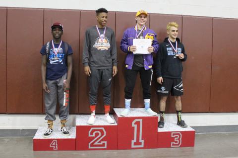 Columbia wrestler Alex McGuigan on the medal stand after winning the Region 1-2A title in the 138-pound weight class on Saturday. (COURTESY)