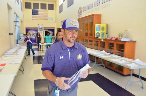 CHS Principal Trey Hosford oversees the distribution of distance-learning packets on Monday, when classes resumed following an extended spring break. Physical schools statewide are still closed to students, forcing school districts to either adopt online classes or pen-and-paper distance-learning methods. (CARL MCKINNEY/Lake City Reporter)