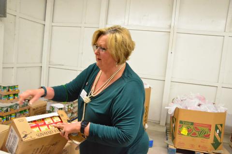 Catholic Charities Regional Director Suzanne Edwards inspects a carton of raisins delivered to the organization’s Florida Gateway Food Bank. Demand for food assistance is surging while the economy is in a holding pattern. (CARL MCKINNEY/Lake City Reporter)