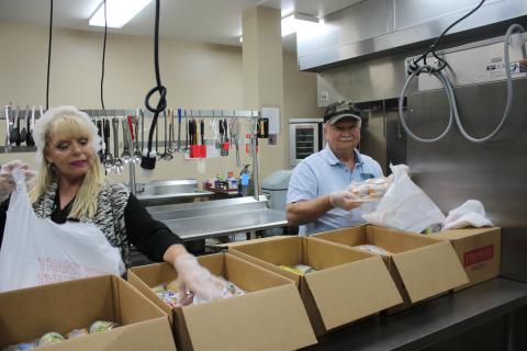 Rose Taylor and Michael Rogers, Columbia County Senior Services drivers, bag frozen meals and other staples for clients of the agency’s Meals on Wheels home-delivery program. The agency has seen a 25% increase in the number of meals it delivers in recent weeks. (TONY BRITT/Lake City Reporter)