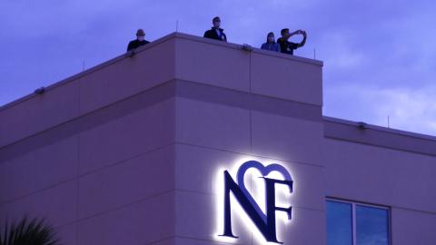 LCMC officials watch the event unfold from the hospital’s roof Sunday night. The Orchard Community Church, which organized the event, estimated that a couple hundred automobiles participated. (TRAVIS LEE/Special to the Reporter)