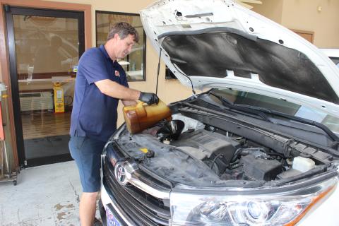 Swift Lube 10-Minute Oil Change co-owner Kevin Swisher pours fresh oil into an SUV at the company’s business location on Knox Street in Lake City Thursday.          morning. Swisher, who owns the business with his brother, Benji, said the volume of their business has declined sharply this month from the “safer at home” order in place statewide. (TODD WILSON/Lake City Reporter)