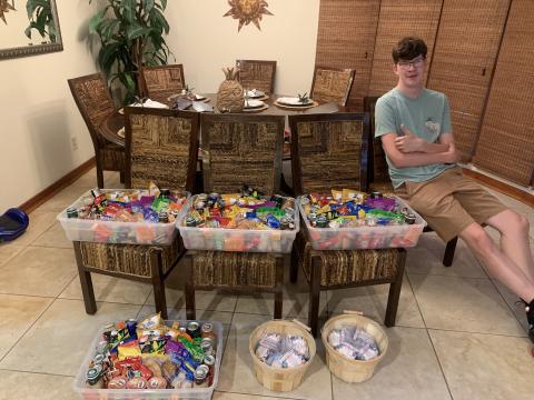 Adam Sandlin poses with baskets of chips, popcorn, sweets and whatever else he could get his hands on. The 18-year-old student at Covenant Community School had a little help raising money from his mother, who has a large presence on social media. (COURTESY)