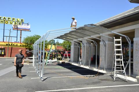 Workers construct an outdoor eating pavilion at Moe’s Southwest Grill, though the franchise’s marketing chief, Ferne Mann, balked a little when she heard a reporter describe the structure that way. “Boy, that’s a fancy name for a shed,” she said. The outdoor eating area will allow the restaurant to serve more dine-in patrons, offsetting restrictions on capacity that will be in place when Florida starts reopening on Monday. (CARL MCKINNEY/Lake City Reporter)