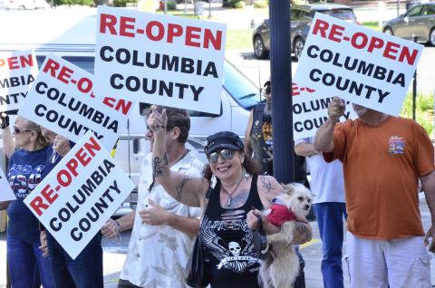 Anti-lockdown protesters march near the Columbia County Courthouse on Tuesday morning. The demonstrators called for all businesses to be allowed to reopen, even as the state has begun relaxing measures in place to curb the spread of covid-19. (CARL MCKINNEY/Lake City Reporter)
