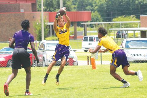 Columbia receiver Jace Hoskey makes a catch during practice last summer with Shyheim Brown (left) and Dante Brown (right) in coverage. (FILE)