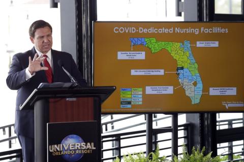 Florida Gov. Ron DeSantis speaks at a news conference at Universal Studios Wednesday, in Orlando. The Universal Studios theme park reopened today for season pass holders and will open to the general public on Friday. Bars and theme parks will be part of Florida's Phase 2 reopening after closure due to the coronavirus pandemic. (AP PHOTO))