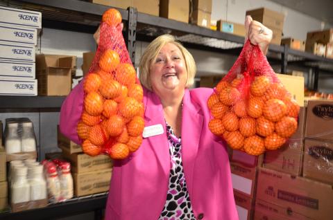 Suzanne Edwards, regional director for Catholic Charities, which operates Florida Gateway Food Bank, holds a couple of bags of oranges at the organization’s HQ on Northwest Railroad Street. (CARL MCKINNEY/Lake City Reporter)