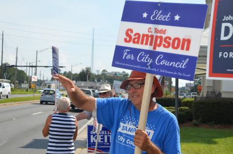 Todd Sampson, waving to traffic along Duval Street on Tuesday afternoon, is headed to a runoff election for the City Council District 13 seat. (CARL MCKINNEY/Lake City Reporter)