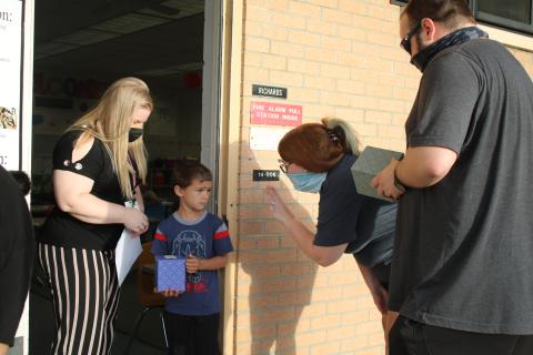 Jessica Richards (from left), a Summers Elementary School kindergarten teacher, looks on as Jayden Wilson watches his parents Ashley DeFreitas and Ryan DeFreitas wave good-bye to him on the first day of school. (TONY BRITT/Lake City Reporter)