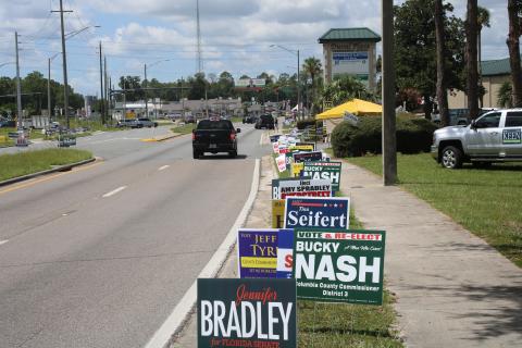 Only a few campaign workers braved 95-degree heat outside the Supervisor of Elections office Monday afternoon. (TONY BRITT/Lake City Reporter)