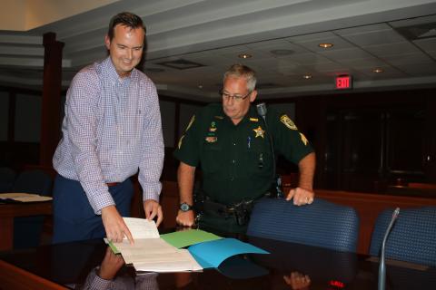Jay Swisher, left, who will be sworn-in as the interim clerk of courts in a private ceremony today, reviews paperwork with Sgt. Mike Sweat of the Columbia County Sheriff’s Office Judicial Division. (TONY BRITT/Lake City Reporter)