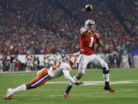 Ohio State quarterback Justin Fields, here throwing a pass while being pressured by Clemson safety K'Von Wallace in the College Football Playoff semifinal at the Fiesta Bowl in December, is among the players hoping to play college football in a safe manner this fall. (KYLE ROBERTSON/TNS)