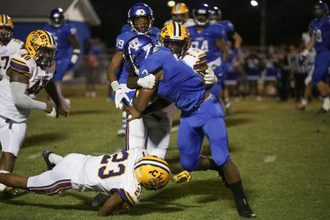 Columbia defensive back Jaden Robinson tackles Trinity Christian running back Treyaun Webb on Friday night. (BRENT KUYKENDALL/Lake City Reporter)
