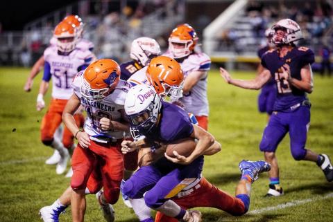 Branford’s Adrik Miller (12) and Clay Williams (11) converge for a tackle against Bell on Sept. 12. (BRIAN LEWIS/Special to the Reporter)
