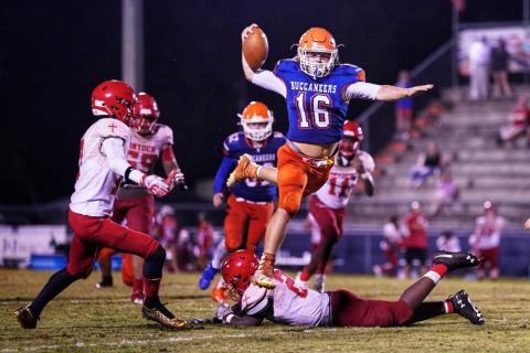 Branford’s Caden Coker leaps over a Bishop Snyder defender Friday night at Cleve Sikes Field at Buccaneer Stadium. (BRIAN LEWIS/Special to the Reporter)