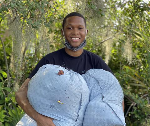 D’Andre Jefferson, holding bags of donated clothes, is hosting a clothing drive after being upset when he saw children mocked for the clothes they were wearing. (JAMIE WACHTER/Lake City Reporter)