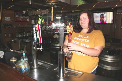 Longbranch Saloon Managing Partner Anita Irwin pulls a Yuengling draught for a customer soon after opening Monday afternoon. Florida bars were allowed to open at 50 percent capacity Monday after covid-19 shutdown restrictions were lifted by the governor. The Longbranch, one of Lake City’s oldest bars, re-opened as a non-smoking venue. (TODD WILSON/Lake City Reporter)