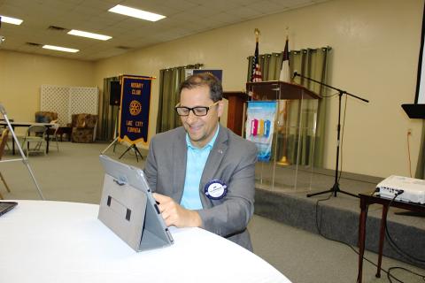 Rotary Club of Lake City President Lee Pinchouck talks to members connecting to a club meeting via Zoom technology as he positions an iPad to video broadcast club activities from the podium behind him prior to the start of Thursday’s meeting. The Rotary Club of Lake City is offering its members hybrid meetings each week either in person or virtually via Zoom. (TODD WILSON/Lake City Reporter)