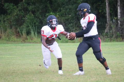 Fort White quarterback Tyler Jefferson hands the ball off to running back Tavion Taylor during Wednesday’s practice. The Indians open the season tonight at Santa Fe. (JORDAN KROEGER/Lake City Reporter)