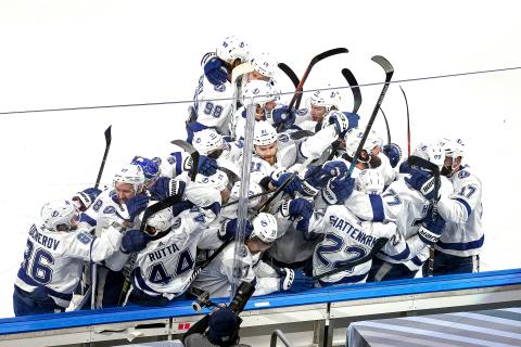 The Tampa Bay Lightning's Kevin Shattenkirk (22) is mobbed by his teammates after scoring the game-winning goal during the first overtime period for a 5-4 victory against the Dallas Stars in Game 4 of the Stanley Cup Finals on Friday, at Rogers Place in Edmonton, Canada. The Lightning lead the series, 3-1. (BRUCE BENNETT/Getty Images/TNS)