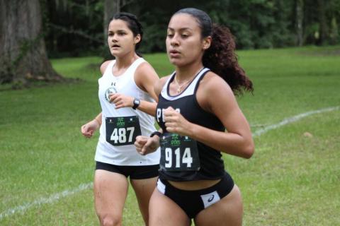 Florida Gateway College runner Merlin Leal (left) runs alongside a Pasco-Hernando State College runner during the Alligator Lake Invitational on Friday. (COURTESY)