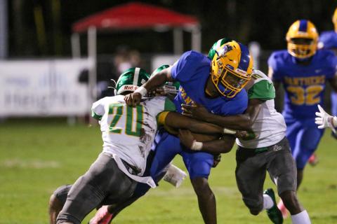 Suwannee’s Travis McKinney (left) and Jay Smith stop Palatka quarterback O’marrion Wilson on a run Friday night. (PALATKA DAILY NEWS)