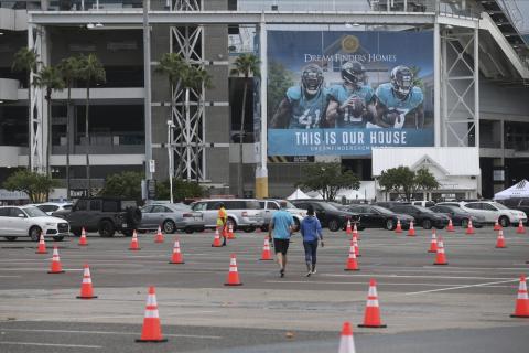 Fans walk through a parking lot with cones to social distance the cars before a game between the Jacksonville Jaguars and the Indianapolis Colts on Sept. 13 in Jacksonville. The Jacksonville Jaguars are the latest NFL team dealing with a positive COVID-19 test. The Jaguars released a statement Saturday, Oct. 17, saying a practice squad player was confirmed as testing positive for the coronavirus a day earlier. (AP FILE PHOTO)