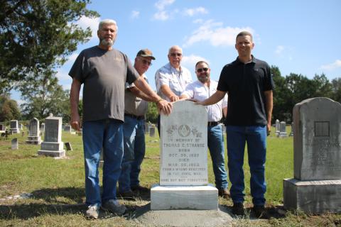 James Smith (from left), stands with Al Williams, Chuck Denmark, Jordan Thrasher and Derek Smith around the headstone of Thomas C. Strange, a Columbia County resident who was reportedly the first Confederate soldier killed in Florida during the Civil War. The Smiths are descendants of Strange, while Williams, Denmark and Thrasher serve as trustees for the cemetery. (TONY BRITT/Lake City Reporter)