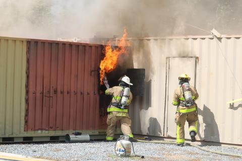 A firefighter uses a hose to douse flames coming from a window during a training session Friday. (TONY BRITT/Lake City Reporter)