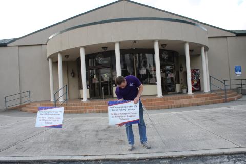 Kent Banner, an elections office staff member, prepares for early voting by adding signs in front of the supervisor of elections office. (TONY BRITT/Lake City Reporter)