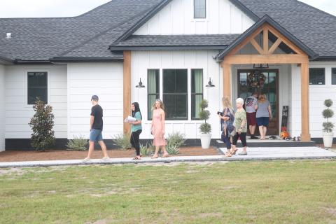 A group of visitors exit the house at 567 NW High Point Drive Saturday while others prepare to enter on the 2020 Parade of Homes. The delayed event featured 10 newly constructed houses around Columbia County and drew a steady crowd both Saturday and Sunday. (JAMIE WACHTER/Lake City Reporter)
