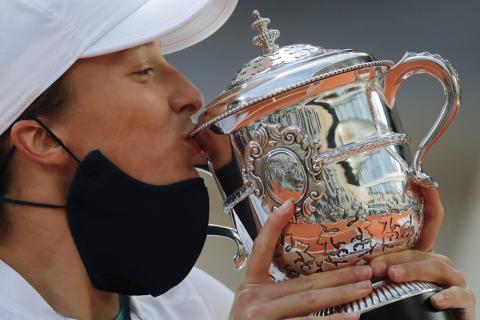 Iga Swiatek kisses the trophy after winning the final match of the French Open against Sofia Kenin in two sets 6-4, 6-1, at the Roland Garros stadium on Saturday in Paris, France. (CHRISTOPHE ENA/Associated Press)