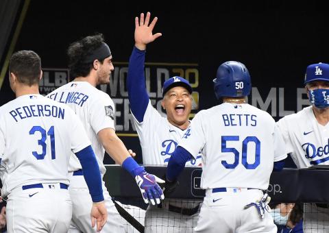 Los Angeles Dodgers manager Dave Roberts, middle, celebrates with Mookie Betts (50), who scored the go-ahead run against the Tampa Bay Rays in the sixth inning during Game 6 of the World Series at Globe Life Field on Tuesday in Arlington, Texas. (WALLY SKALIJ/Los Angeles Times/TNS)