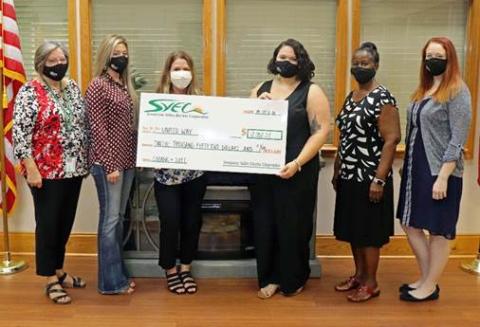 Suwannee Valley Electric Cooperative employees present Jennifer Anchors, the executive director of the United Way of Suwannee Valley with a check for $12,052, which includes a matching grant from CoBank. (COURTESY)
