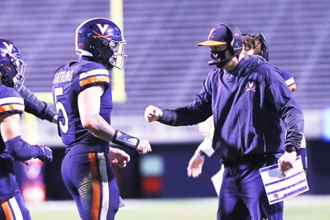 Virginia coach Bronco Mendenhall talks with quarterback Brennan Armstrong during a game against Louisville on Nov. 14 in Charlottesville. (ERIN EDGERTON/Daily Progress/TNS)